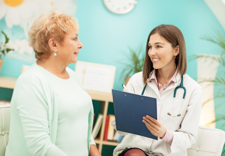 Une patiente en consultation avec une médecin discutant d'un programme de suivi santé pour l'arthrose